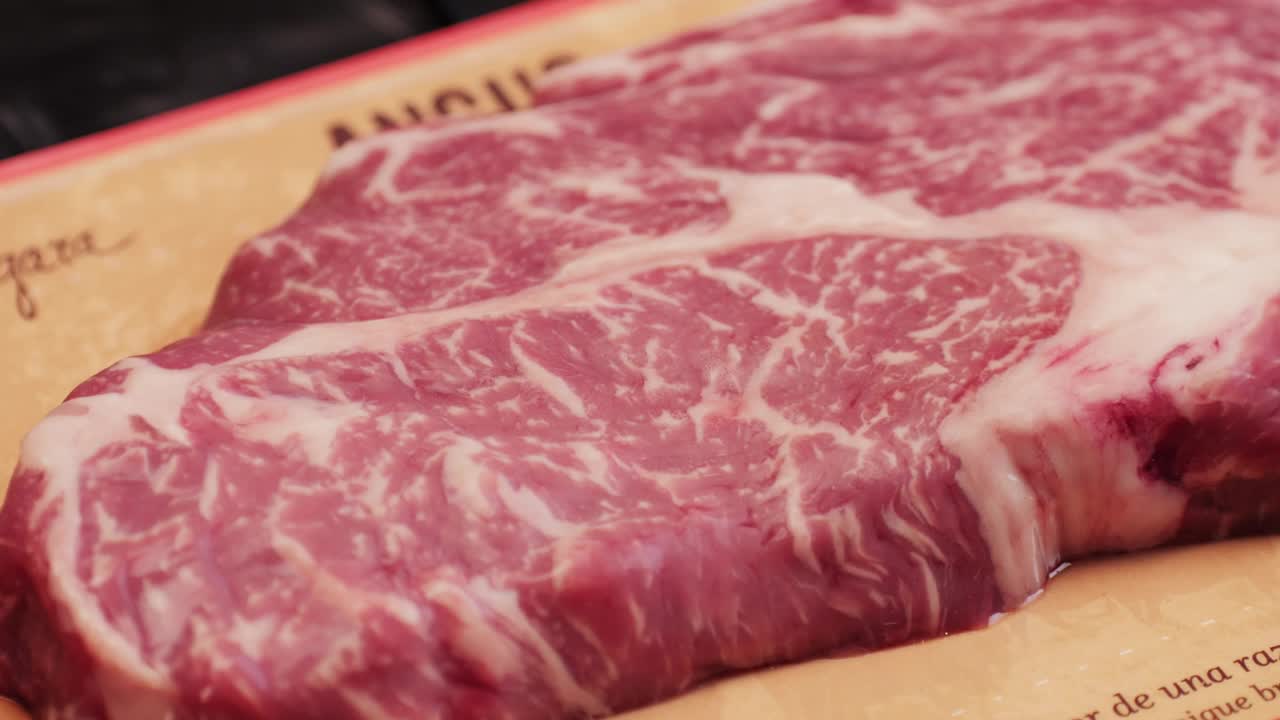新鲜的大理石牛肉与胡椒，盐和迷迭香特写特写。准备烤多汁的牛排。优质有机生和牛肉