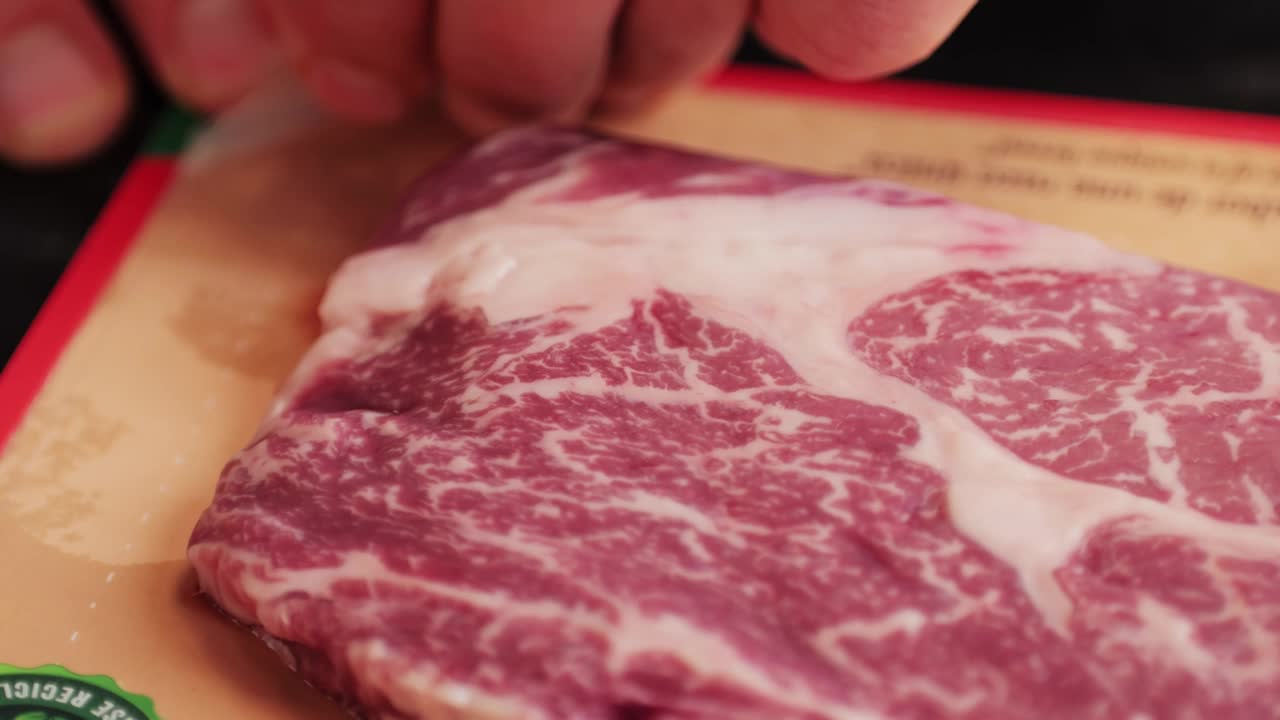 新鲜的大理石牛肉与胡椒，盐和迷迭香特写特写。准备烤多汁的牛排。优质有机生和牛肉