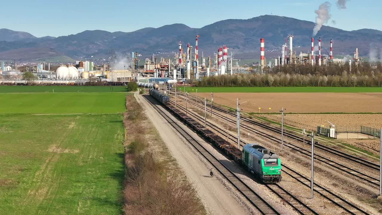 以阿尔萨赫米工厂为背景的绿色铁路机车，阳光明媚的日子，工业场景