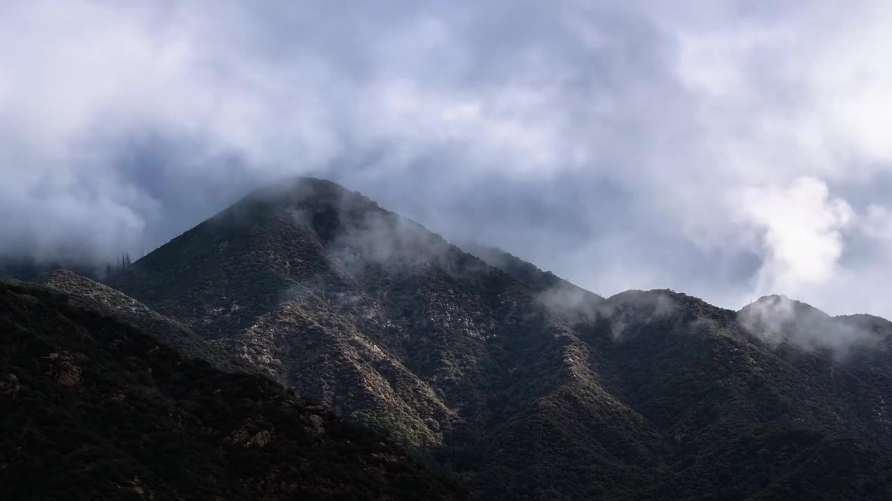 在圣贝纳迪诺国家森林的蓝天上，笼罩在圣戈尔戈尼奥山脉上空的大气薄雾和云层(60fps)