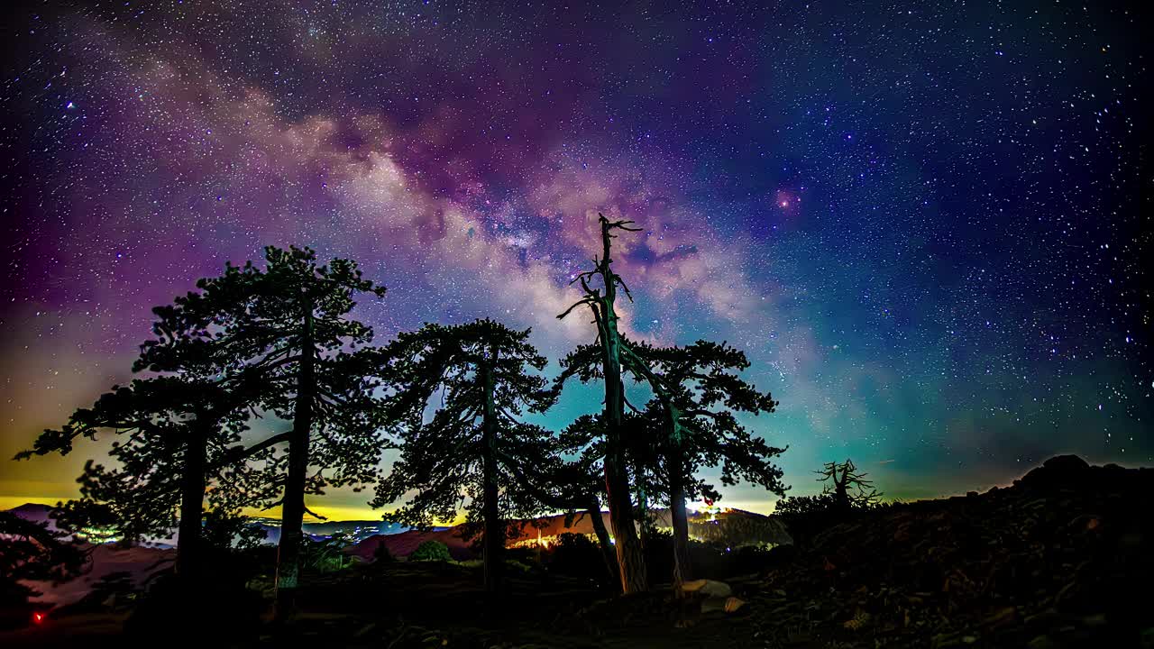 彩色的銀河在營地上方漆黑的夜空中流逝