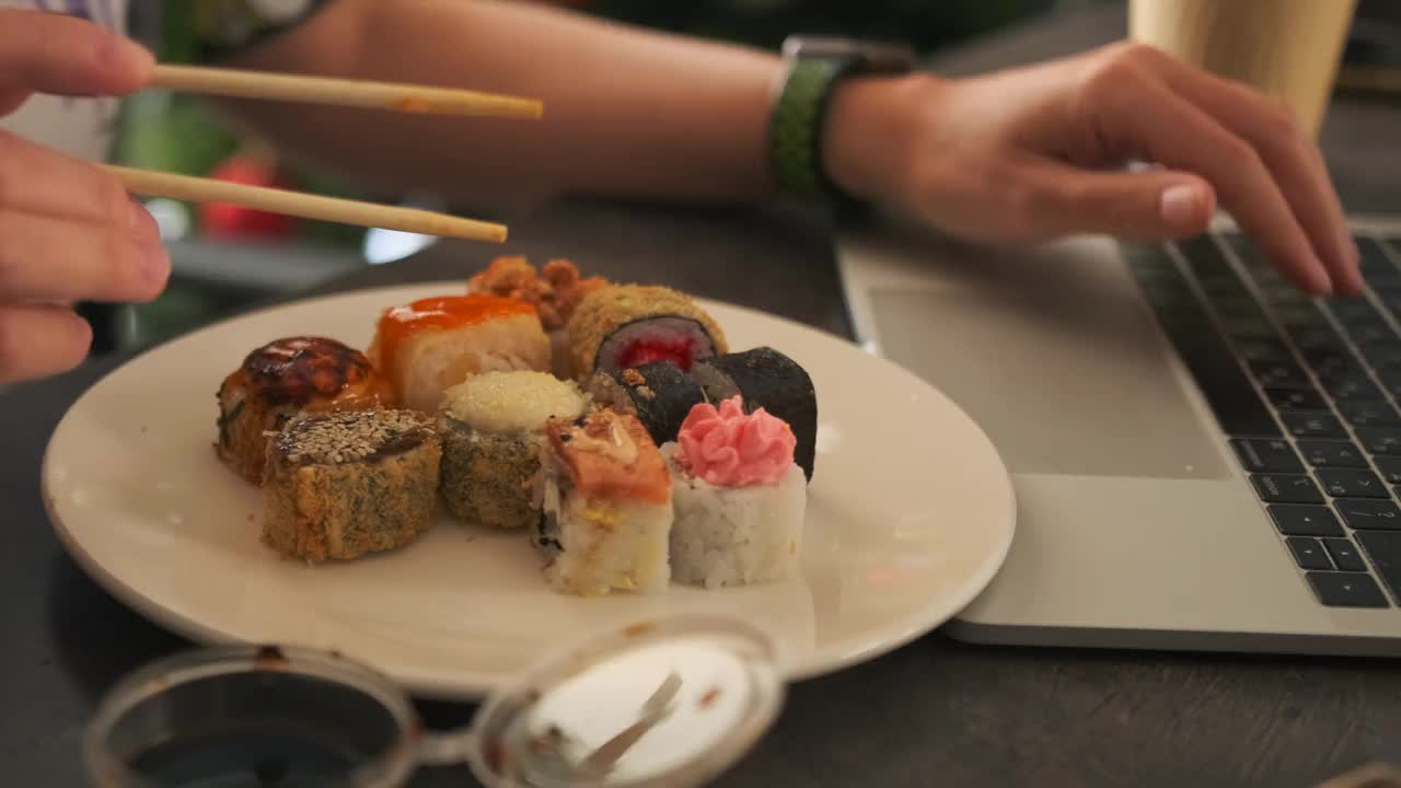 特写手拿亚洲卷，蘸酱和芥末，背景