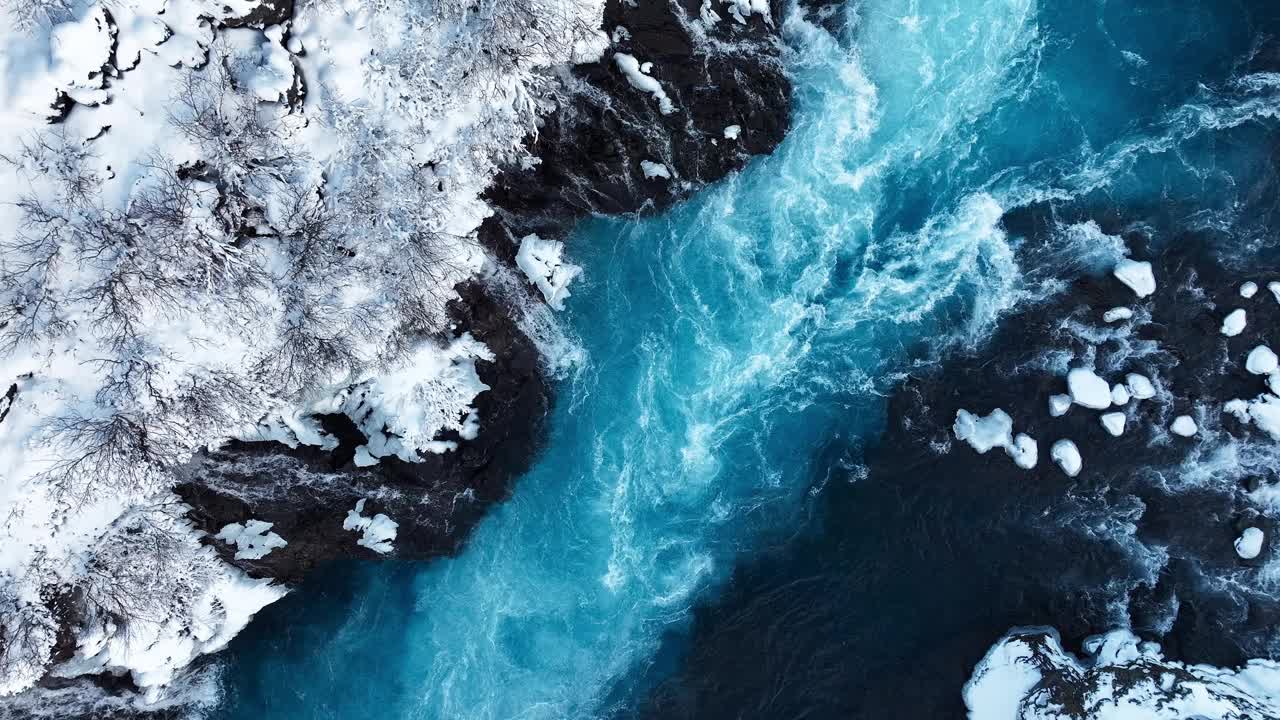 冰岛的瀑布，冬天的雪山和寒冷的河流，冰雪的神奇冬季时间位置，蓝色的冰川水和巨大的电流。纯净的风景景观。Hraunfossar。