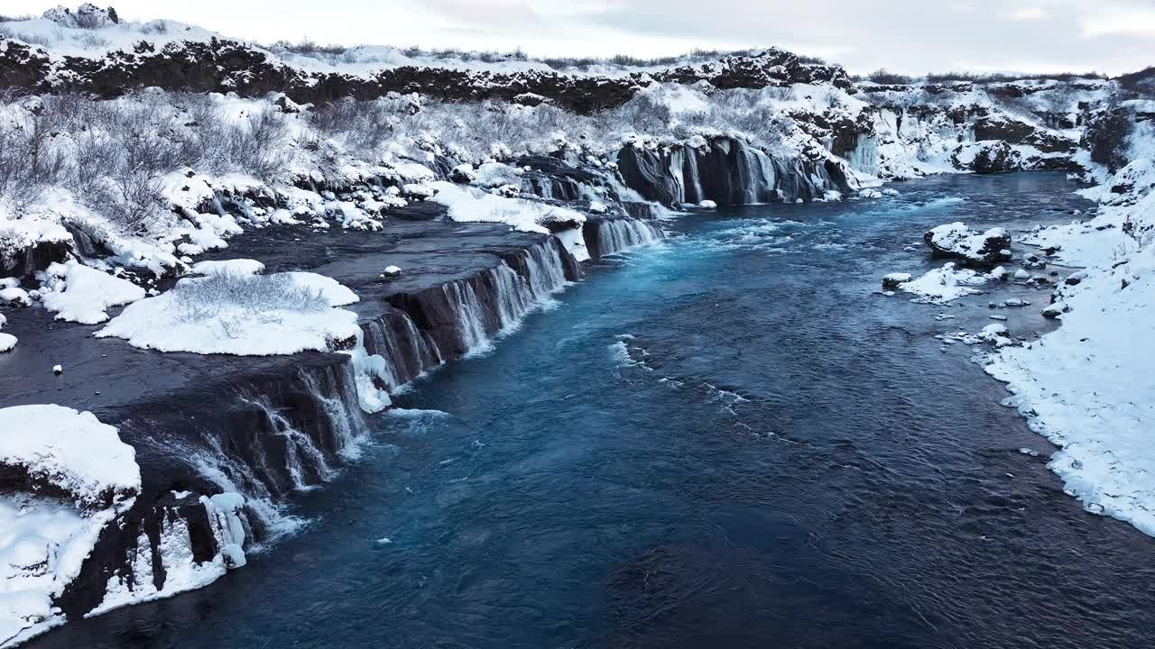 冰岛的瀑布，冬天的雪山和寒冷的河流，冰雪的神奇冬季时间位置，蓝色的冰川水和巨大的电流。纯净的风景景观。Hraunfossar。