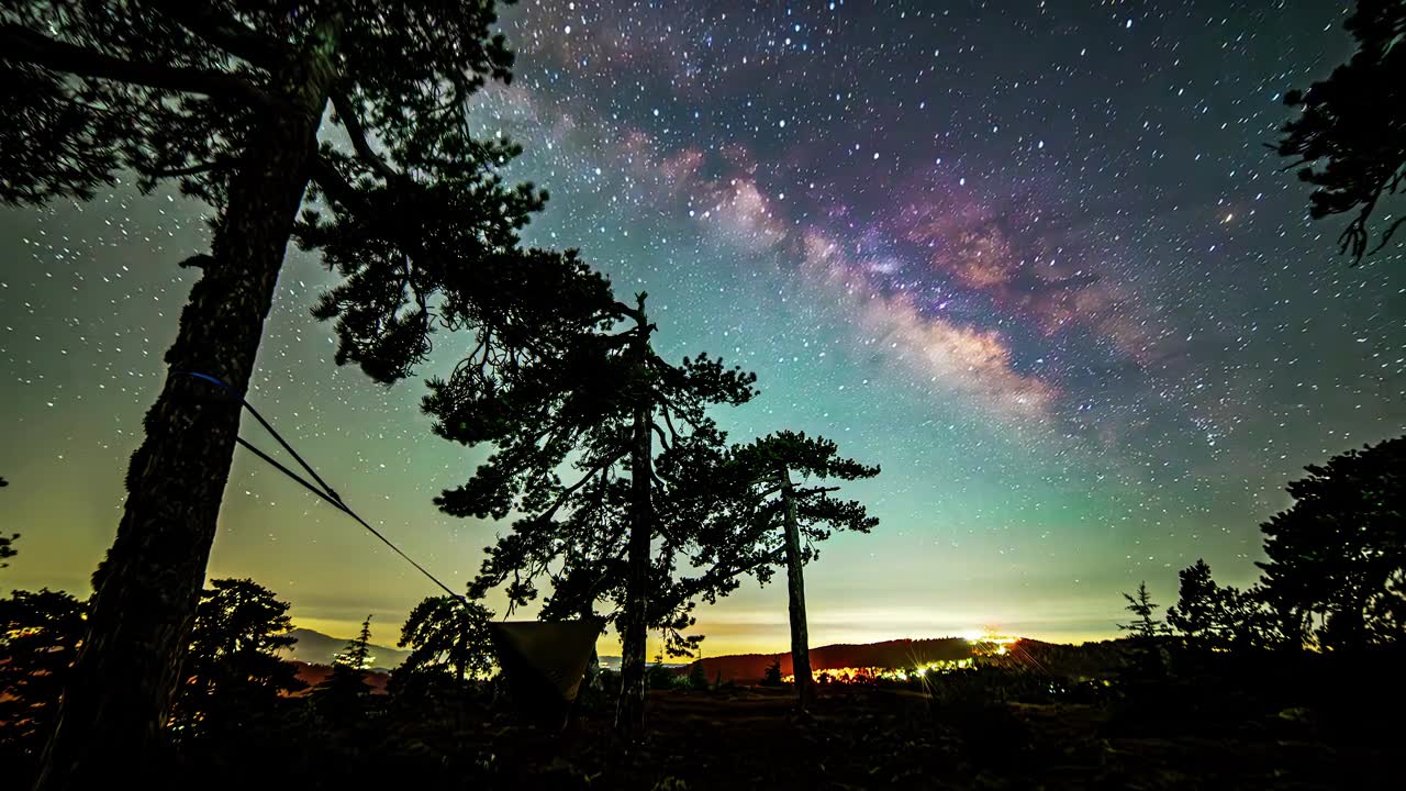 詳情圖-延時(shí)拍攝，彩色銀河在山上移動(dòng)，夜空中的樹(shù)帳星
