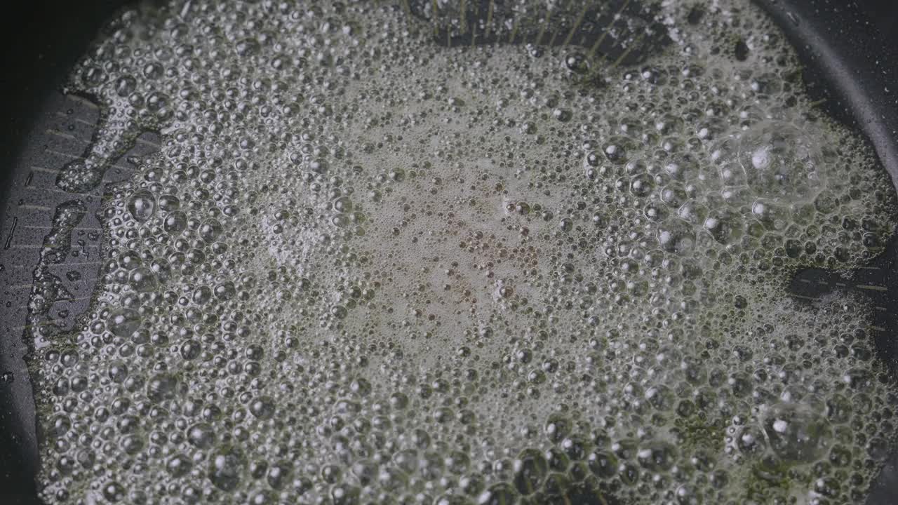 在厨房的铁锅里用新鲜的黄油煎新鲜的鲑鱼排。