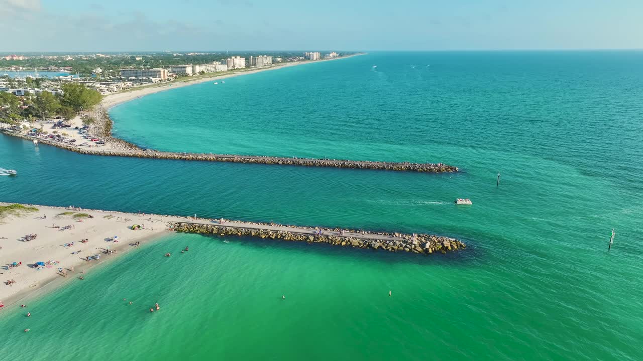 佛罗里达州威尼斯附近的海岸鸟瞰图，白色的游艇漂浮在海浪上。诺科米斯海滩的南北码头。水上摩托艇娱乐