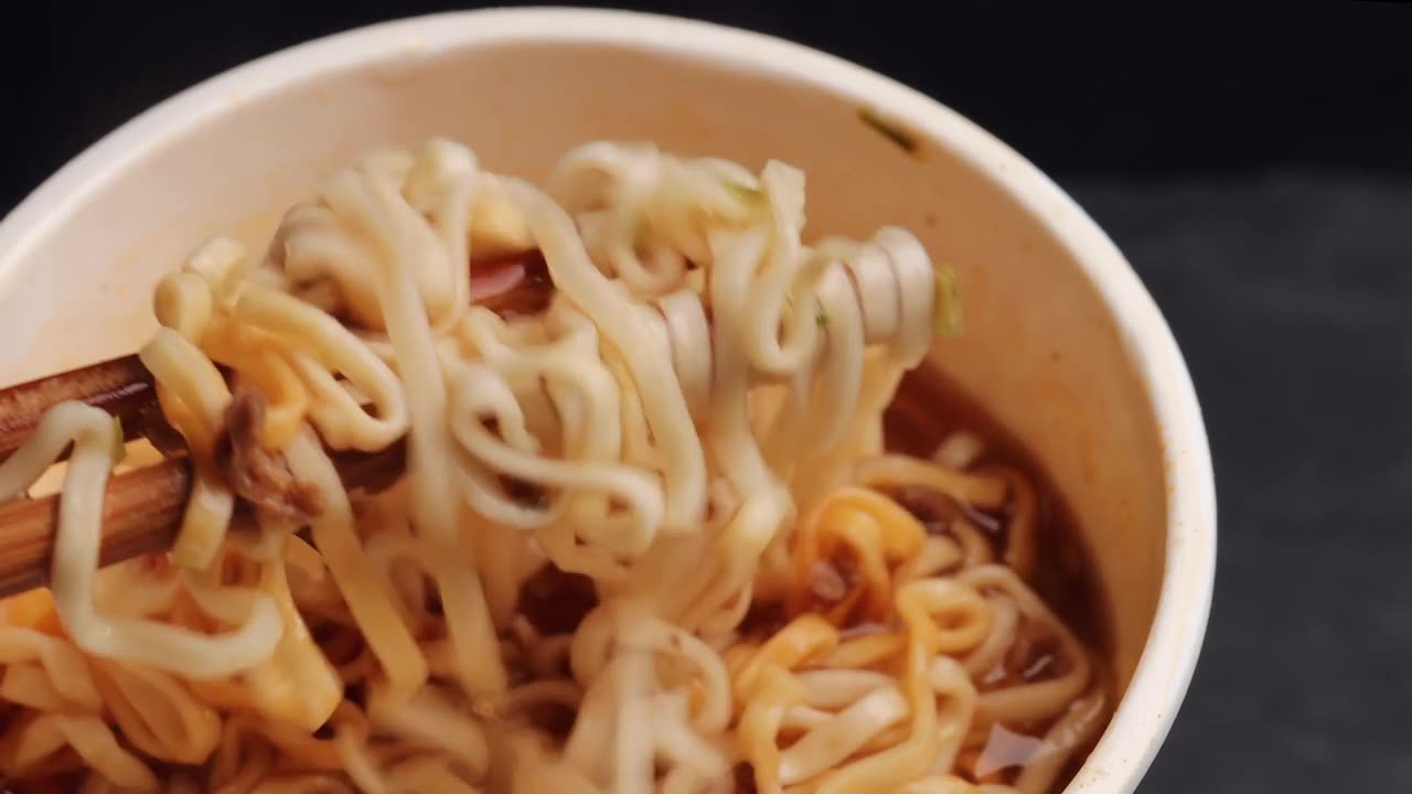 详情图-用木筷子夹着美味的面条。用筷子夹面条