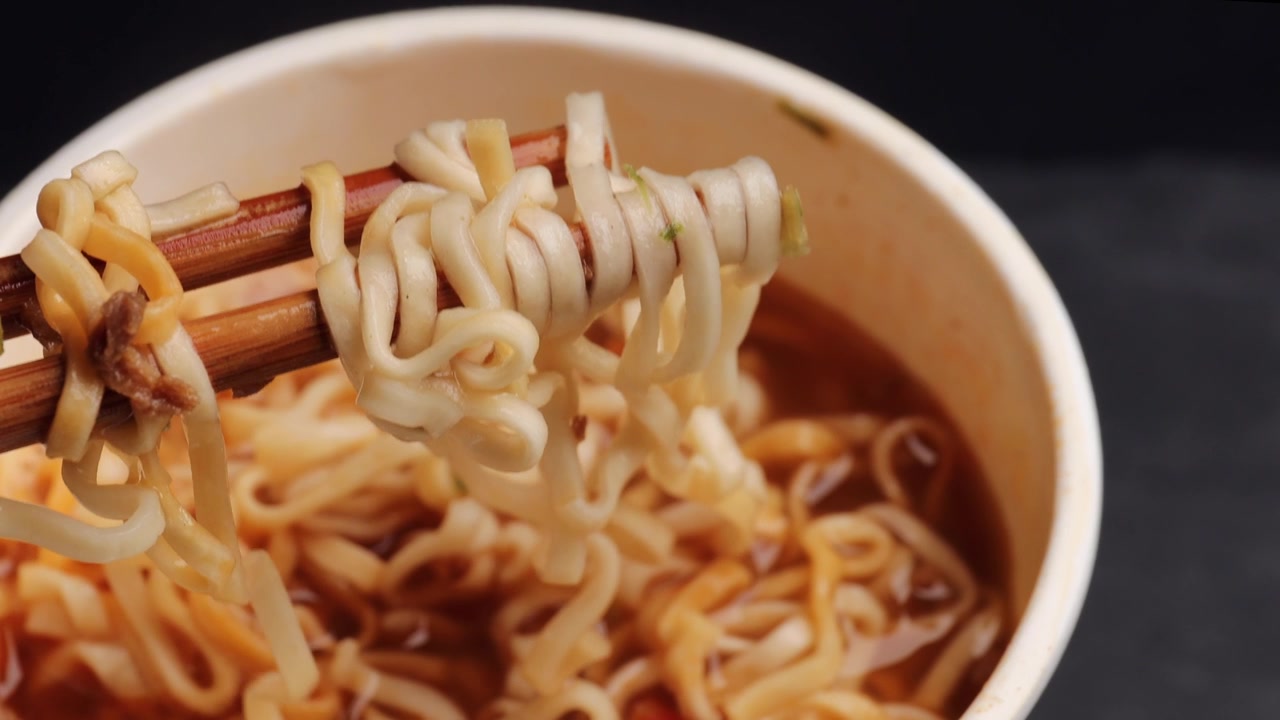 详情图-用木筷子夹着美味的面条。用筷子夹面条