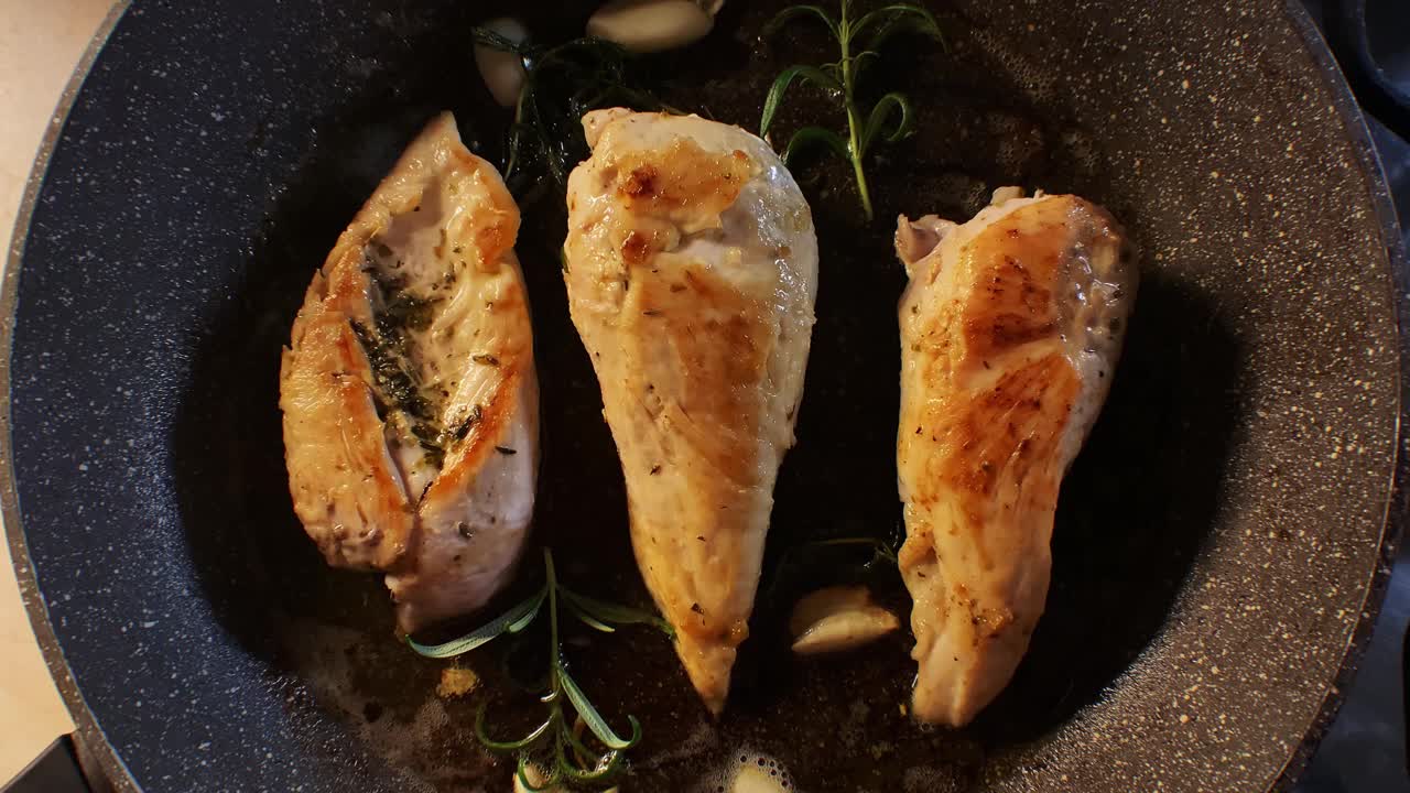用平底锅煎香草鸡胸肉。用迷迭香和大蒜烹制。俯视图