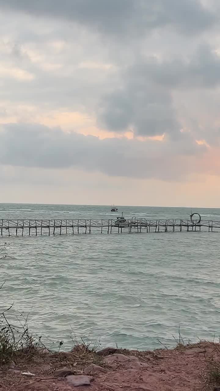 渔场飞越巴图尔湖岸边的养鱼场，湖水碧绿。在阳光明媚的日子里，以火山和蓝天为背景的海岸景观，鱼漂浮农场和渔网。