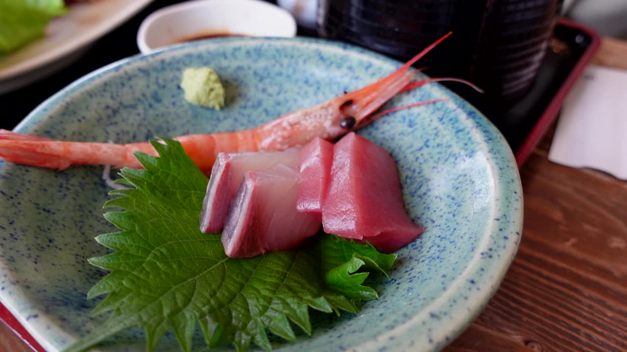 在日本当地的海滩餐厅，用手筷子吃日本新鲜海鲜饭，配生鱼片和炸鱼