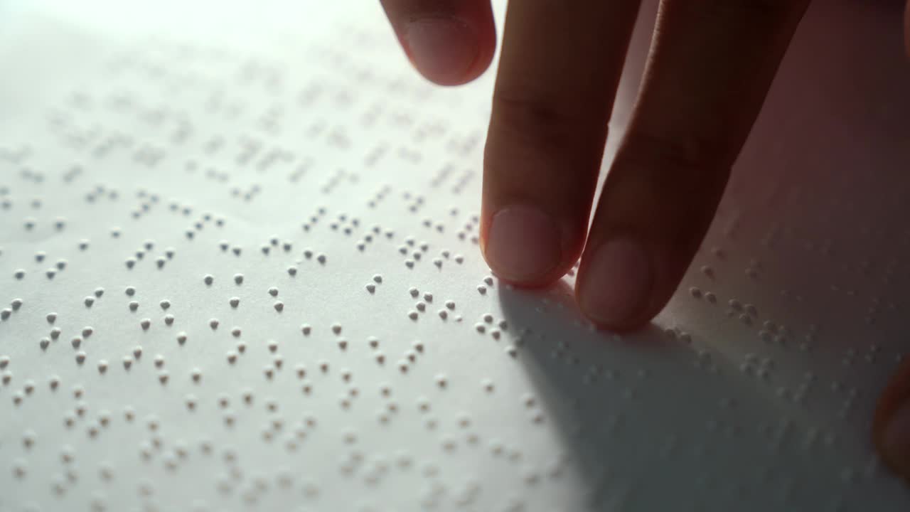 盲人的手阅读一些盲文在纸上学习。盲人学生的手指触摸着纸上的盲文字母代码。残疾人概念。