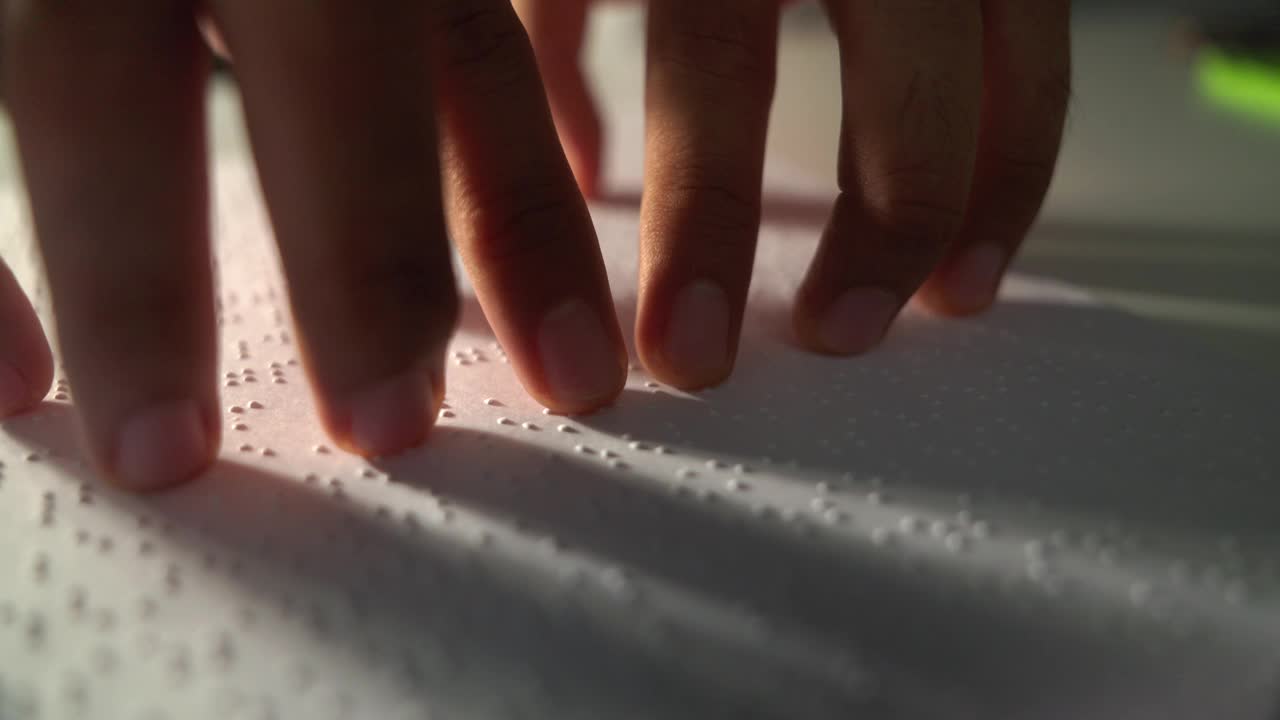 盲人的手阅读一些盲文在纸上学习。盲人学生的手指触摸着纸上的盲文字母代码。残疾人概念。