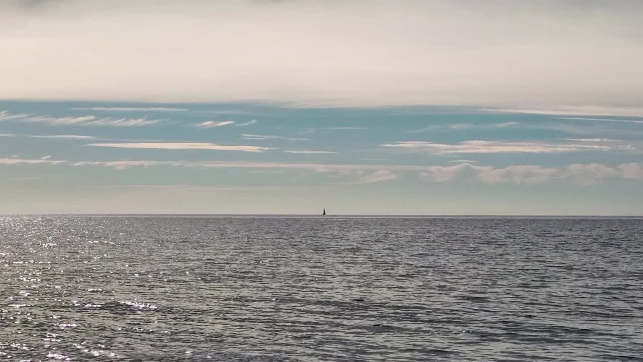 湛蓝的天空，平静的大海，地平线上有帆。节日气氛平静，节日气氛平静