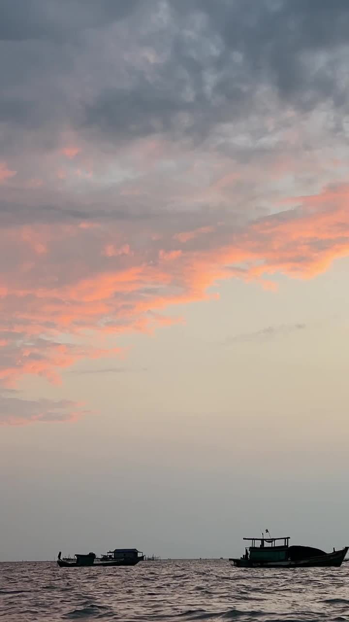 渔船的剪影漂浮在海上与夕阳的天空渔夫船的剪影漂浮在海上夕阳的天空