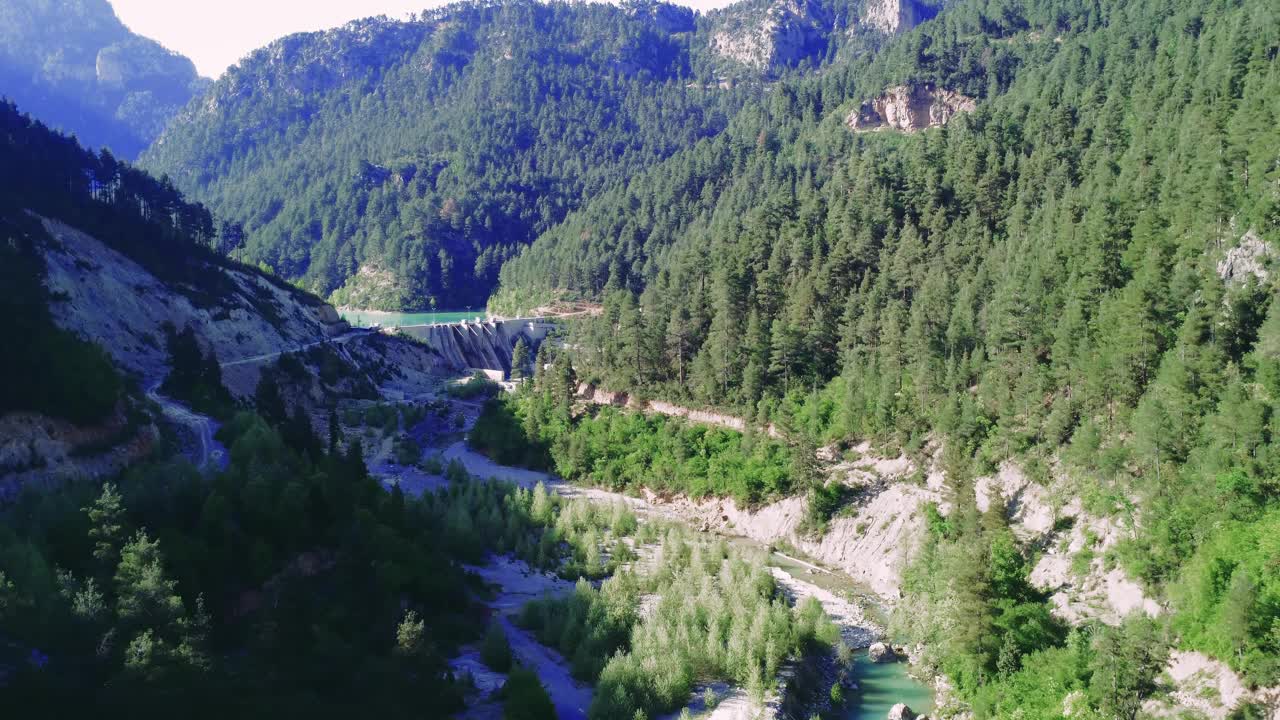 水力发电，无人机拍摄的水坝画面，山谷场景。水力发电，水坝鸟瞰图，翡翠湖可见。水力发电，树木繁茂的山谷中的水坝，无人机视频