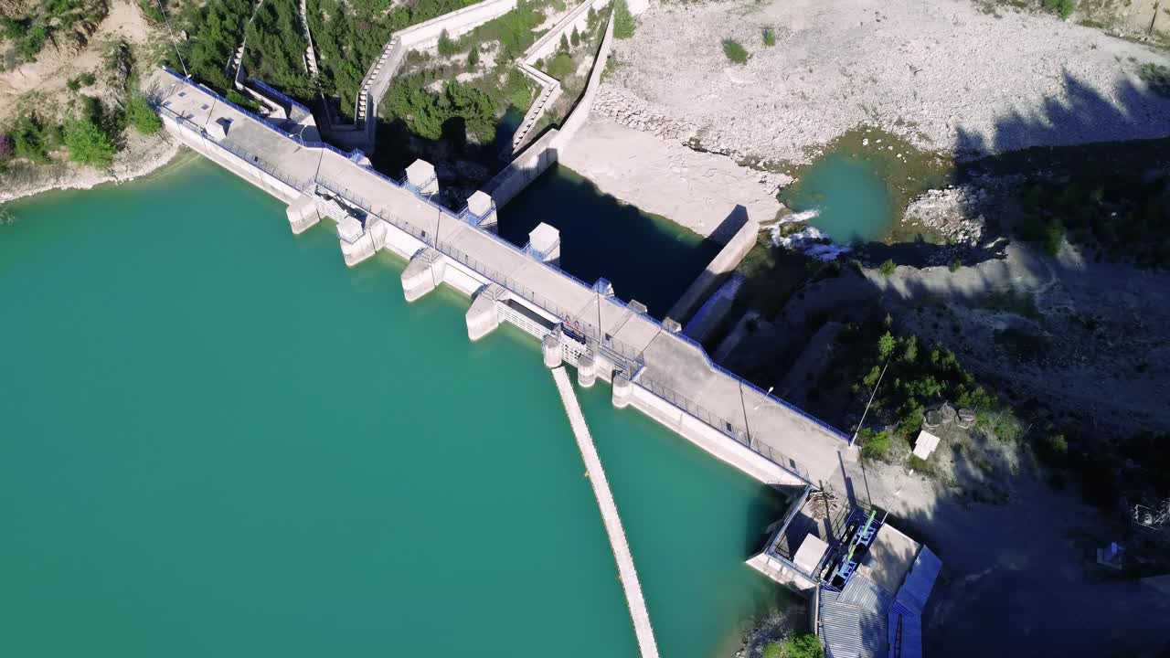 在山谷中拍摄的水库，无人机视图。水库水色翠绿，湖中绿树成荫。水库和大坝航拍图，隐蔽区域