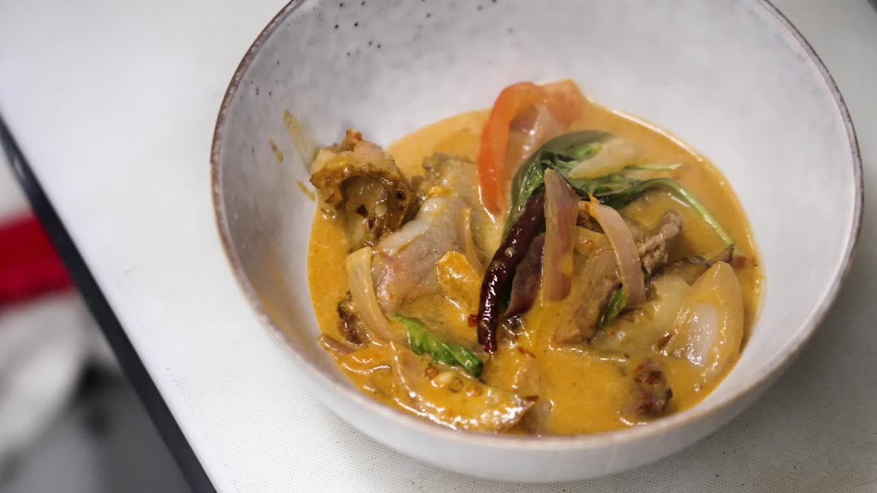用勺子盛满泰式红咖喱牛肉，4K