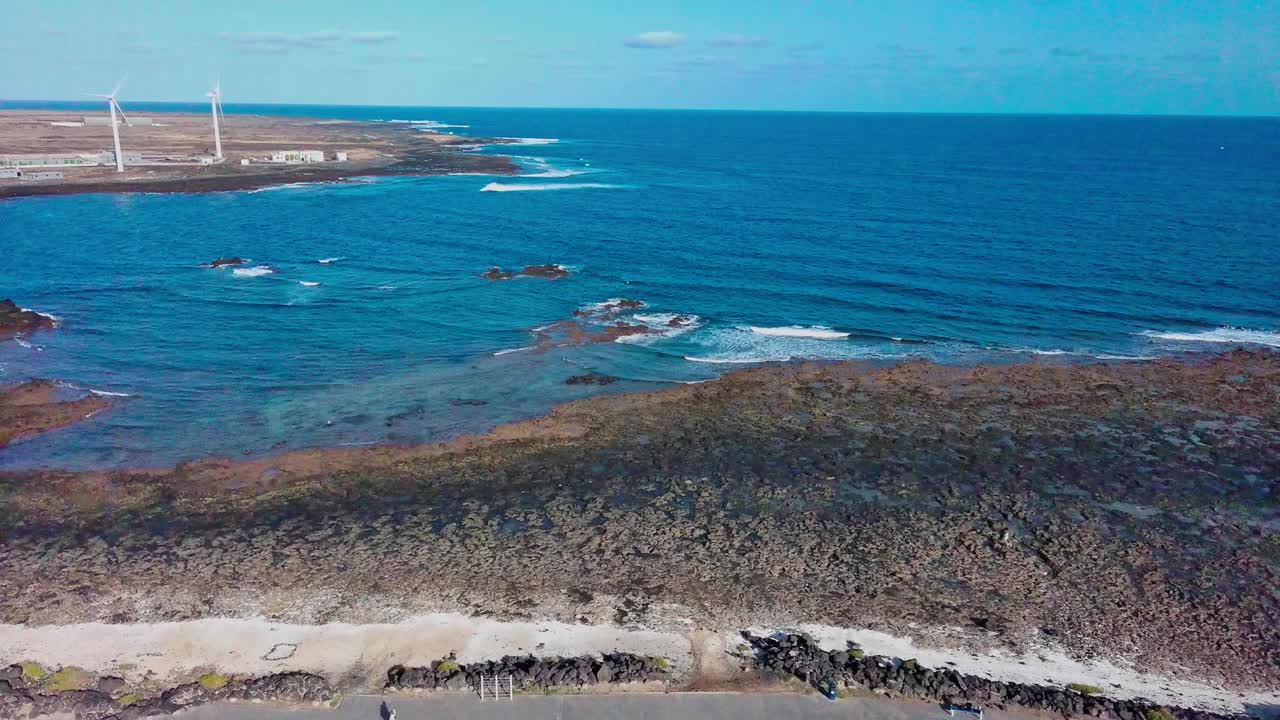 富埃特文图拉科拉雷霍的岩石海岸线和海浪，风力涡轮机，鸟瞰图