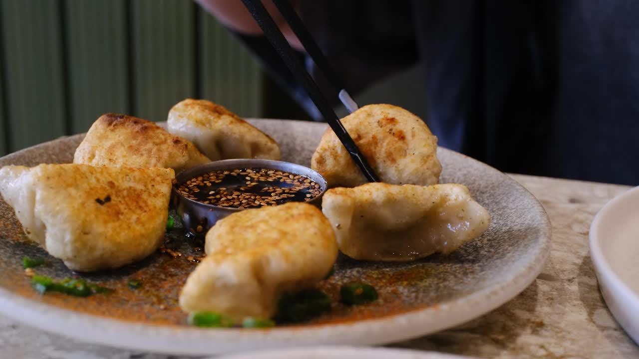 在白色的盘子里盛上了酱油的日式饺子，这是一种中国和日本当地的常见食物