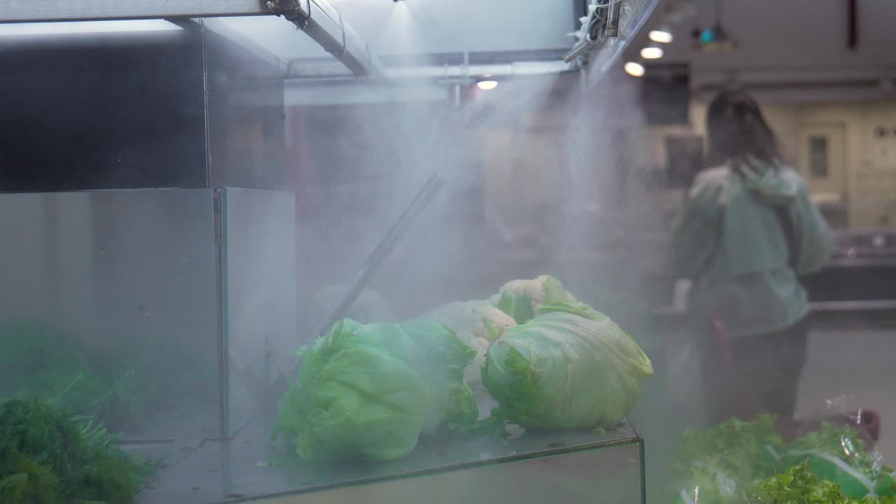 杂货店里的新鲜蔬菜在冷却的水蒸汽下。