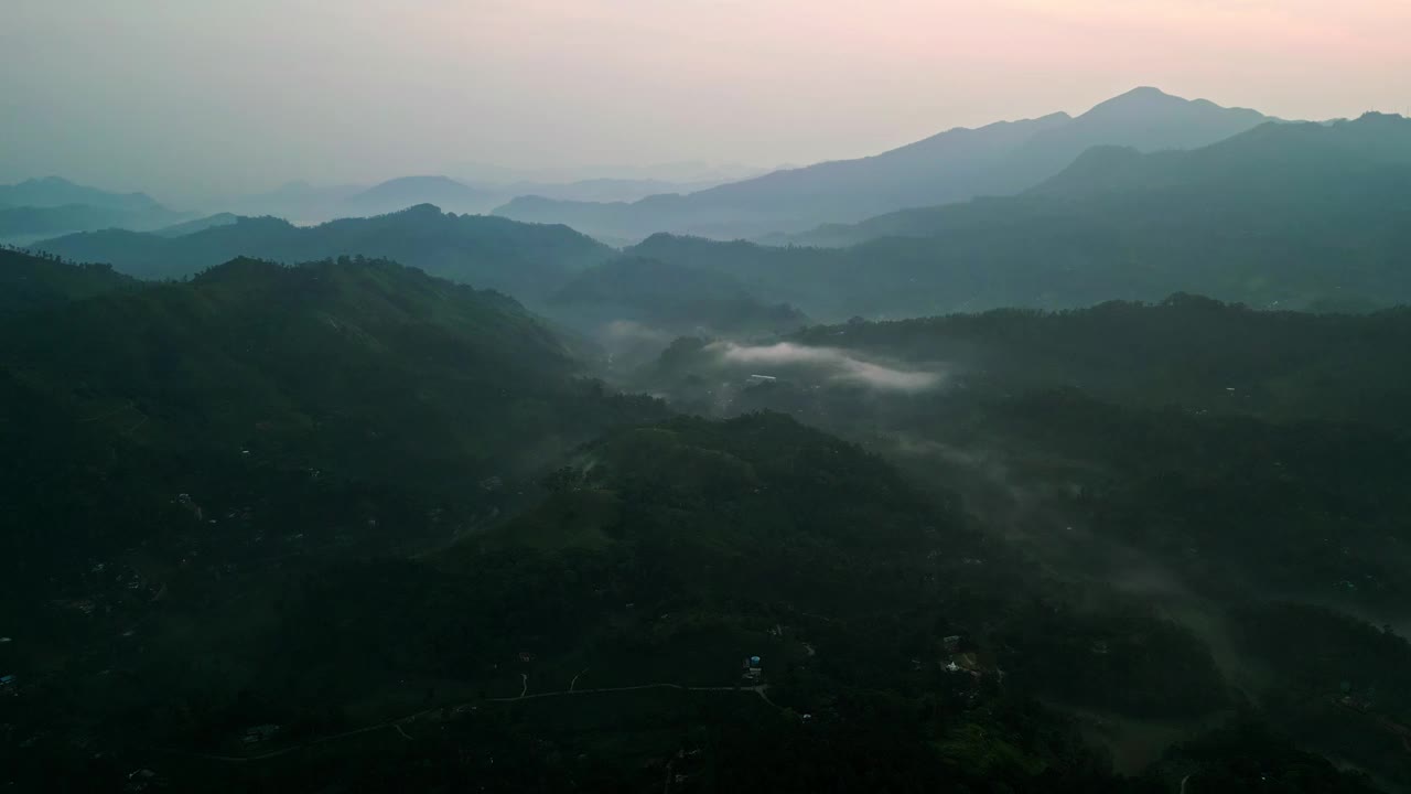 无人机在斯里兰卡薄雾笼罩的艾拉山脉上空冉冉升起。显露出山谷和高峰。大自然爱好者，游客探索清晨。令人叹为观止的风景，为寻求宁静，美丽的旅行。