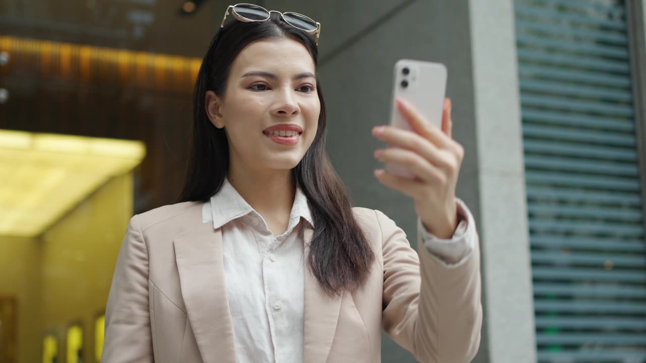 详情图-白人女商人站在城市里，用智能手机品牌进行视频通话或视频会议。5G无线技术，随时随地工作。