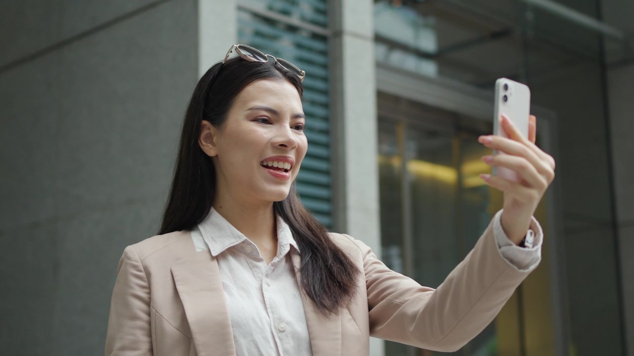 详情图-白人女商人站在城市里，用智能手机品牌进行视频通话或视频会议。5G无线技术，随时随地工作。