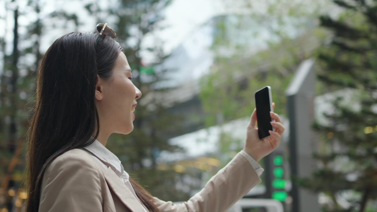 详情图-白人女商人站在城市里，用智能手机品牌进行视频通话或视频会议。5G无线技术，随时随地工作。