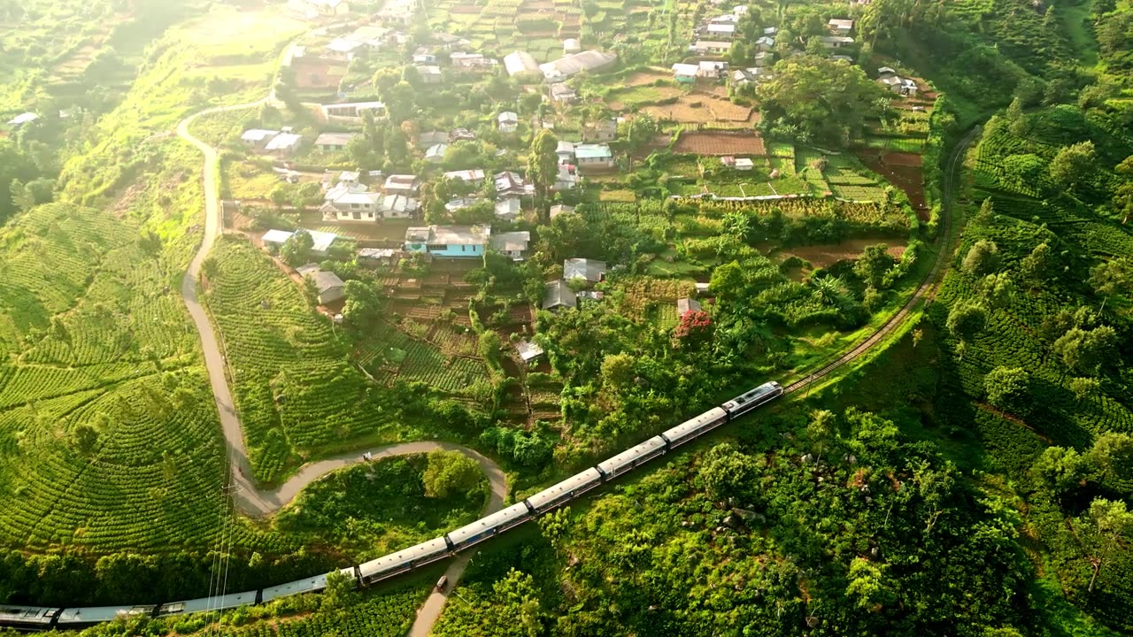 詳情圖-火車蜿蜒穿過郁郁蔥蔥的哈普塔萊山脈，穿梭在生機(jī)勃勃的綠茶田里。航拍拍攝斯里蘭卡鄉(xiāng)村風(fēng)景優(yōu)美的旅行。旅游業(yè)和農(nóng)業(yè)融合在一片寧靜的風(fēng)景中。