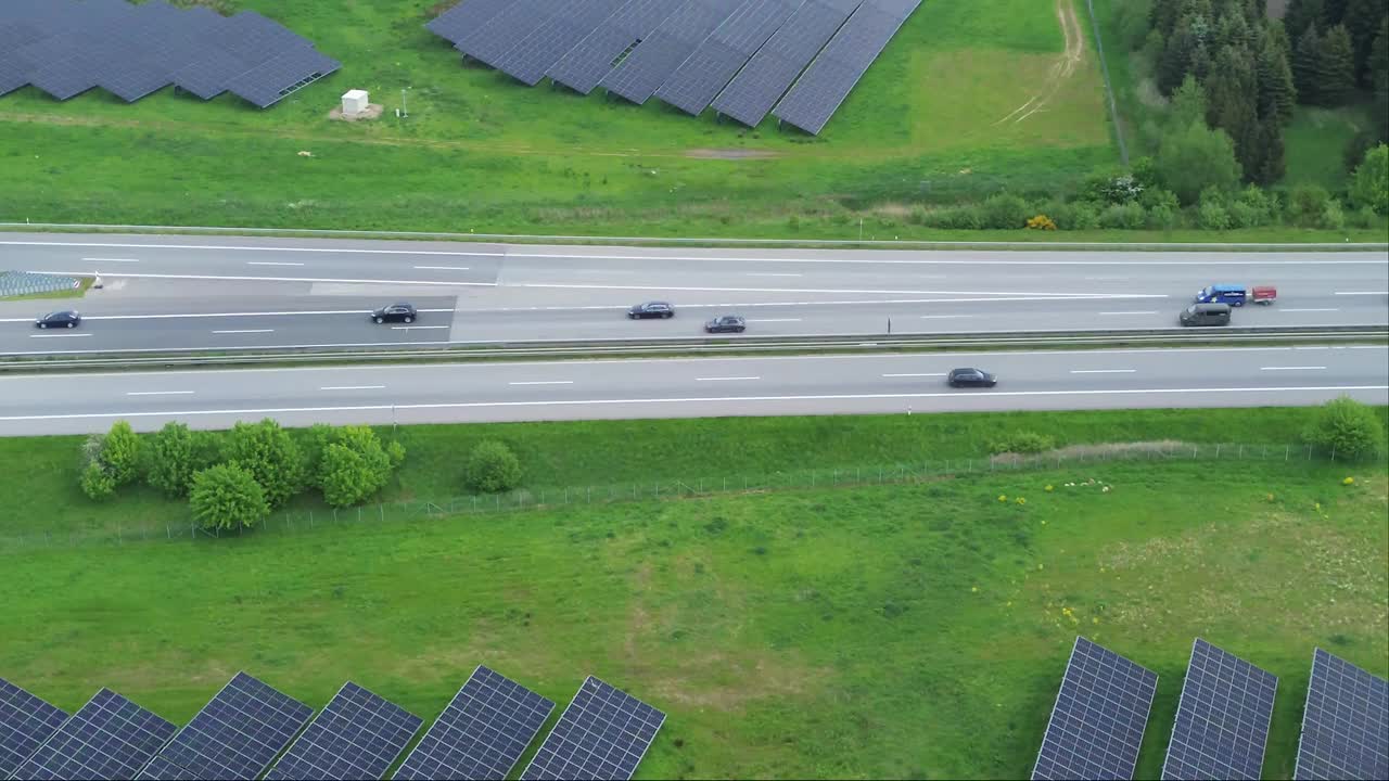 德国高速公路上的无人机飞行，交通繁忙，路边有大型太阳能电池板。