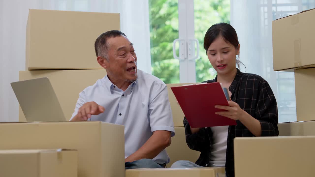 亚洲老年人使用笔记本电脑和年轻女性使用智能手机在家里检查电子邮件订单中小企业，创业小企业的企业家退休后从事网络营销，商人的概念