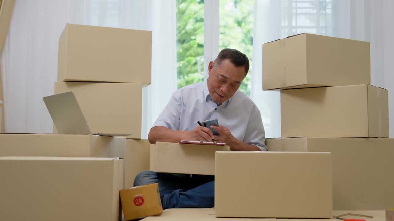 亚洲老年人，老年人使用笔记本电脑和智能手机检查电子邮件订单在家里，办公室中小企业，创业小企业的企业家，退休后工作的在线营销，商人卖家的概念