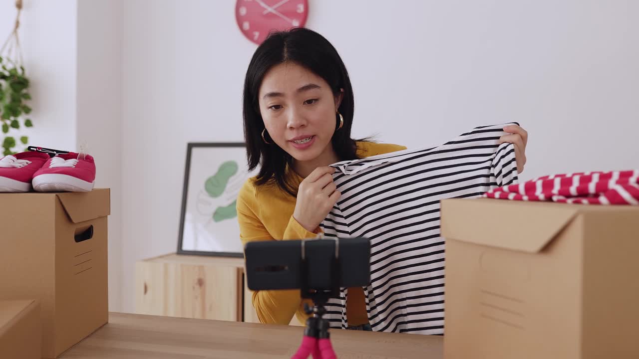 詳情圖-年輕的亞洲女性用手機(jī)拍攝關(guān)于時(shí)尚新聞和服裝產(chǎn)品的視頻