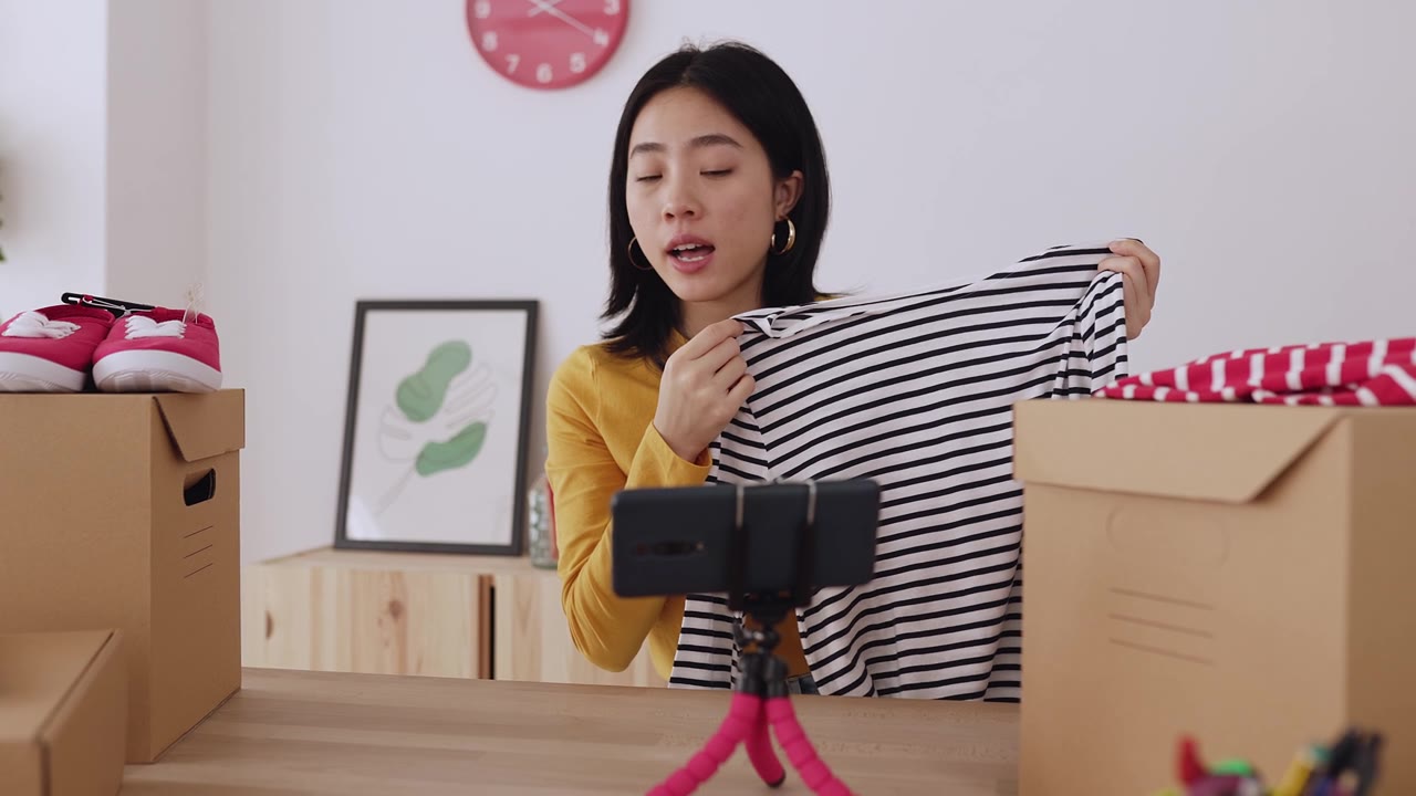 詳情圖-年輕的亞洲女性用手機(jī)拍攝關(guān)于時(shí)尚新聞和服裝產(chǎn)品的視頻