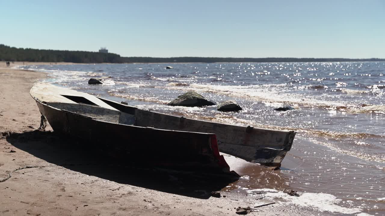 海湾的沙滩上，一艘被遗弃的破损渔船