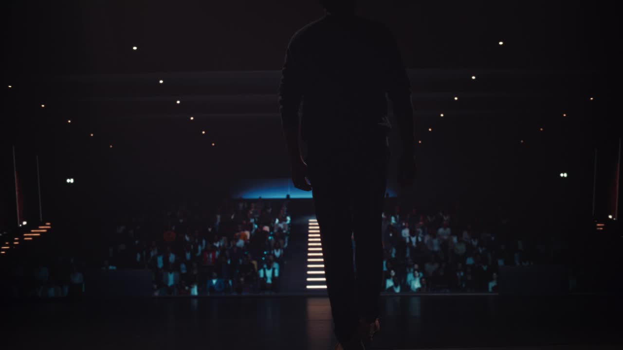 南亚演讲人走上讲台欢迎听众。商人用有力的演讲和有力的手势来激励观众购买他的产品