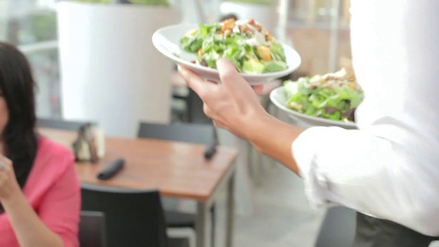 餐厅服务员为三位女性朋友准备午餐