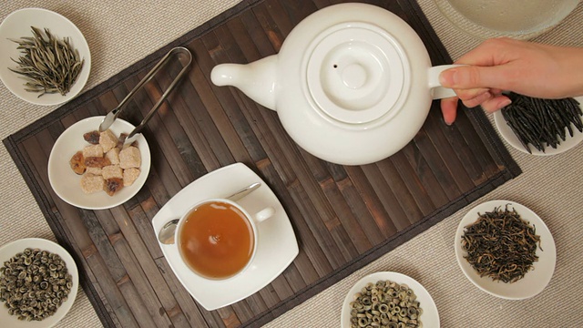 从茶壶里倒茶的女人