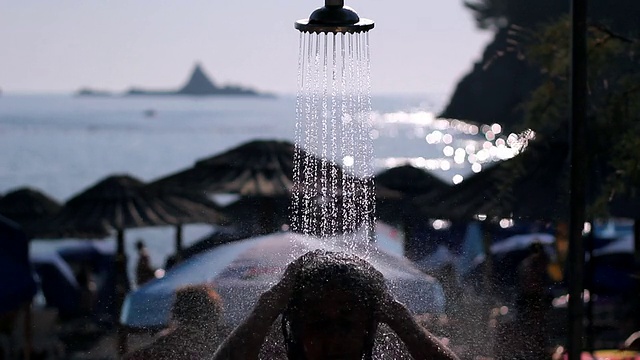 在海滩淋浴下的青少年