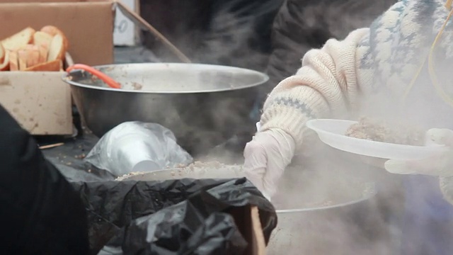 穷人得到一顿户外冬季城市食物捐赠