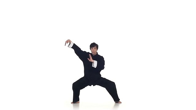 武术或空手道男子身穿黑色和服在白色背景下，动作缓慢