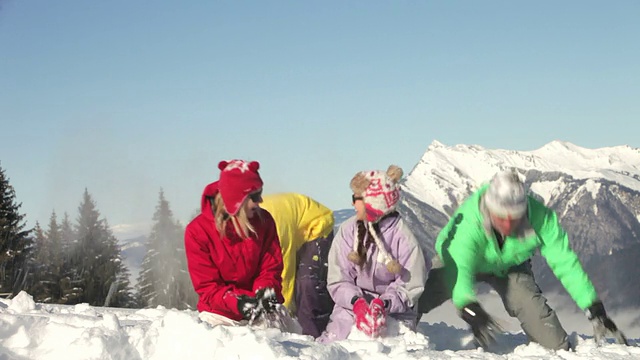 青少年家庭在山上打雪仗