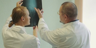 男性和女性医生检查x射线图像