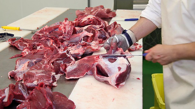 屠夫在屠宰场切牛肉