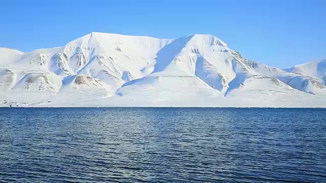 北冰洋的波浪和斯匹次卑尔根群岛白雪皑皑的山脉。