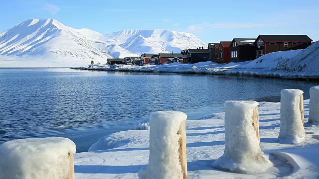 挪威斯瓦尔巴特群岛冰雪覆盖的群山中，北冰洋沿岸的一个小镇。