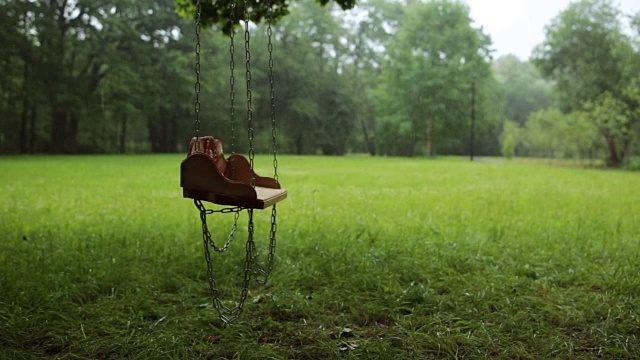 空空的木秋千在雨中慢慢地摇摆