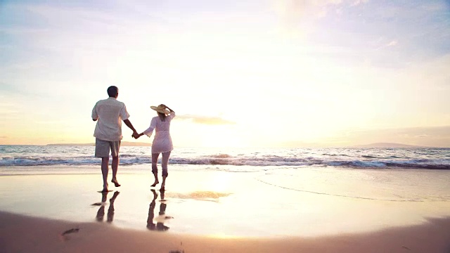 详情图-日落漫步海滩。老夫妇手牵着手，奔向夕阳，让他们的脚湿了